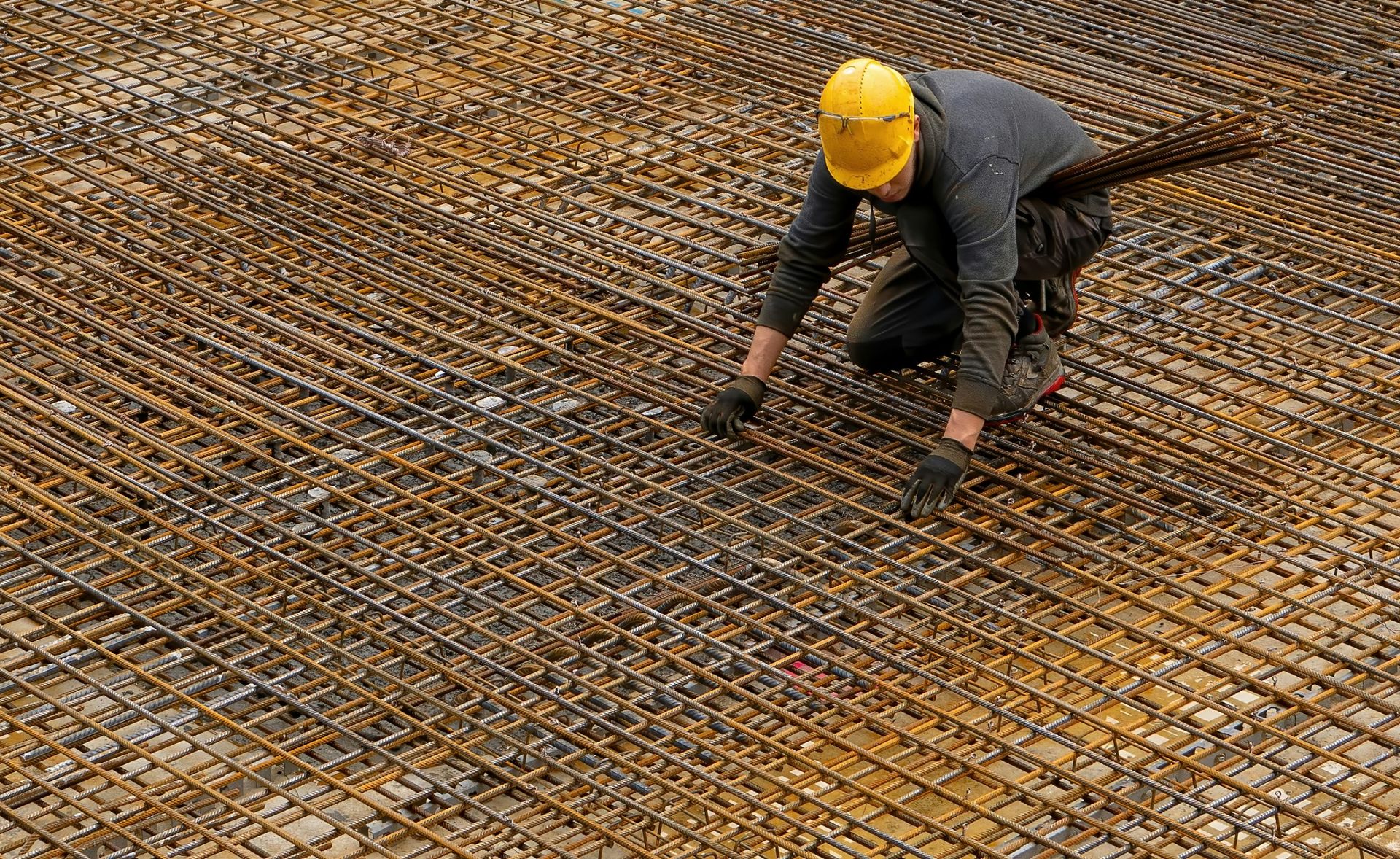 Steel fixer working on rebar mesh